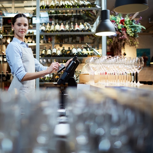 Une serveuse qui encaisse un client
